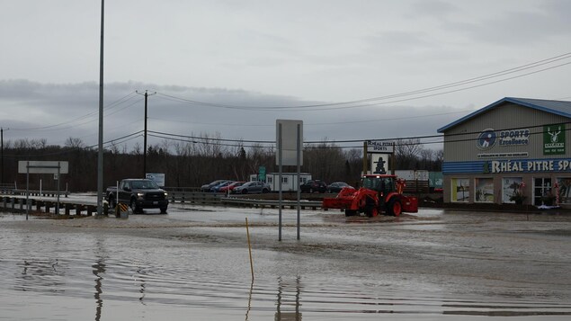 Un tracteur et une voiture circulent sur la route inondée, le 2 décembre 2020.