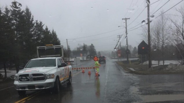 Une voiture et une barrière bloquent la route. Une voiture et une barrière bloquent la route.