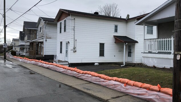 Une barrière de sacs de sable longe le trottoir d'une rue de Gatineau