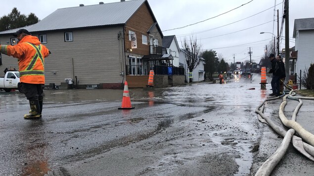 Un agent dirige la circulation dans une rue inondée du village.