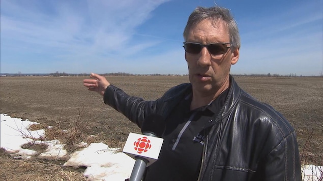 Un homme portant des verres fumés répond aux questions de la journaliste. Un homme portant des verres fumés répond aux questions de la journaliste.