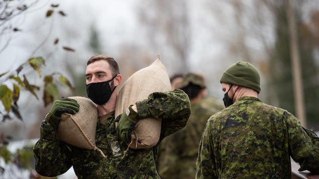 عناصر من الجيش يحملون أكياسا من الرمل.