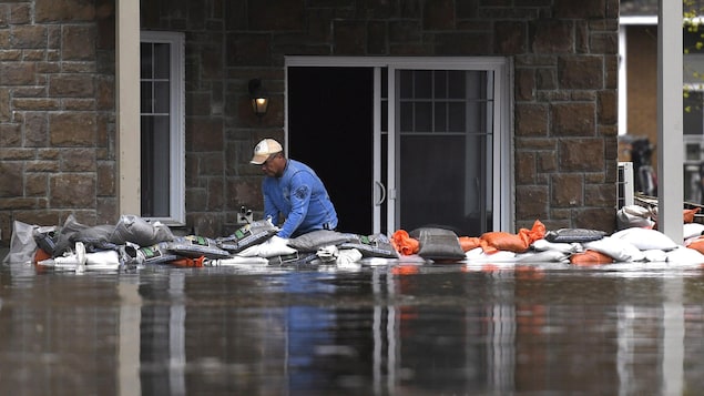 Un sinistré de Gatineau tente de prévenir les dégâts que pourraient causer les inondations à son appartement avec des sacs de sable.