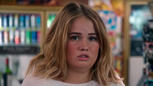 L'actrice Debby Ryan est dans un supermarché et regarde quelque chose qui la rend triste dans la série «Insatiable».