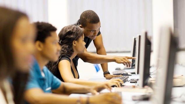 Des étudiants devant des écrans d'ordinateur.