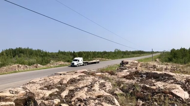 A truck driving on a deserted road. 