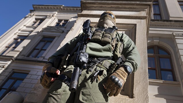 Un soldat cagoulé se tenant devant l'édifice.