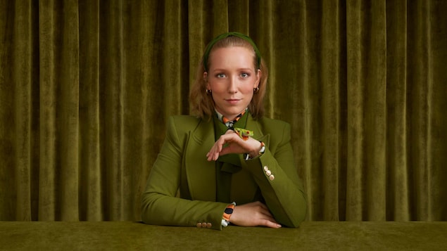 Maude Landry habillée en vert, dans une pièce verte, avec une grenouille.