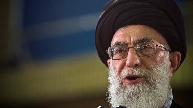 L'ayatollah Ali Khamenei, ayant une barbe et portant des lunettes, parle dans un micro. L'ayatollah Ali Khamenei, ayant une barbe et portant des lunettes, parle dans un micro.