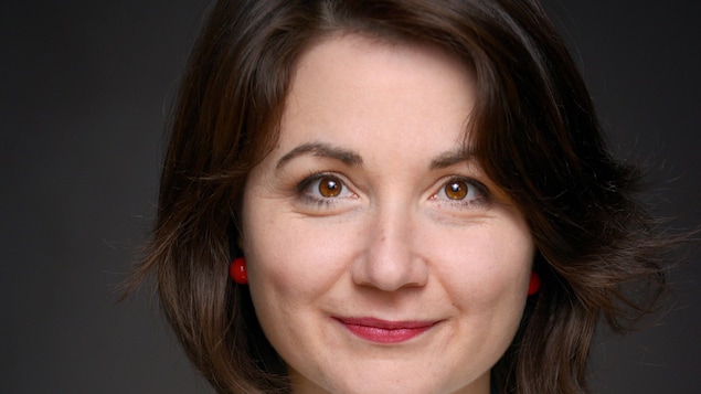 Elle sourit à la caméra.