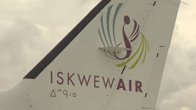 Plan serré d'un logo sous lequel il est écrit Iskwew Air sur l'aileron arrière d'un avion. Plan serré d'un logo sous lequel il est écrit Iskwew Air sur l'aileron arrière d'un avion.