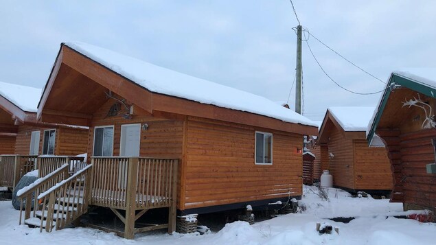 Une cabine en bois sous la neige.