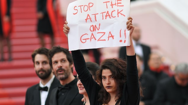 L'actrice Manal Issa, vêtue de noir, brandit une affiche. L'actrice Manal Issa, vêtue de noir, brandit une affiche.