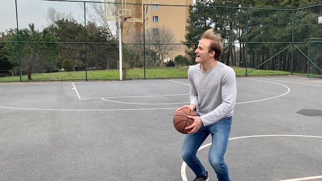 Un jeune homme joue au basket.