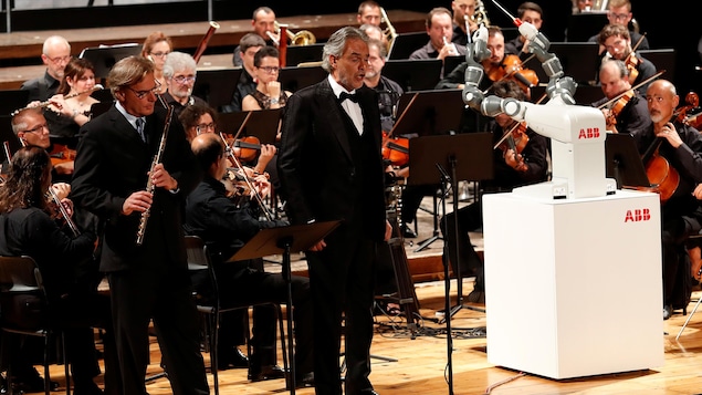 Au théâtre Verdi de Pise, en Italie, le ténor italien Andrea Bocelli a chanté quelques minutes accompagnées des musiciens de l’orchestre philharmonique Lucca dirigés par… le robot humanoïde YuMi. Au théâtre Verdi de Pise, en Italie, le ténor italien Andrea Bocelli a chanté quelques minutes accompagnées des musiciens de l’orchestre philharmonique Lucca dirigés par… le robot humanoïde YuMi.