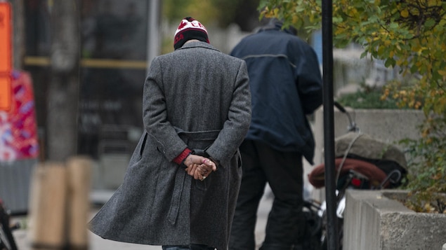 Deux hommes de dos sur un trottoir.