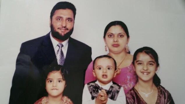 La famille pose sur un fond blanc, les enfants sourient. La famille pose sur un fond blanc, les enfants sourient.