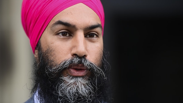 Un gros plan sur le visage d'un homme qui porte la barbe longue et un turban.