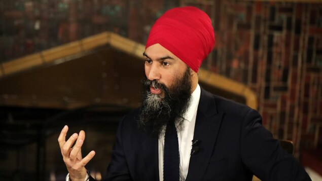 Le chef du Nouveau Parti démocratique du Canada, Jagmeet Singh en costume cravate parle avec la main levée