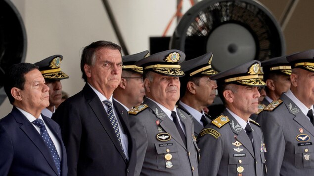 Le président brésilien Jair Bolsonaro en rangée avec des militaires.