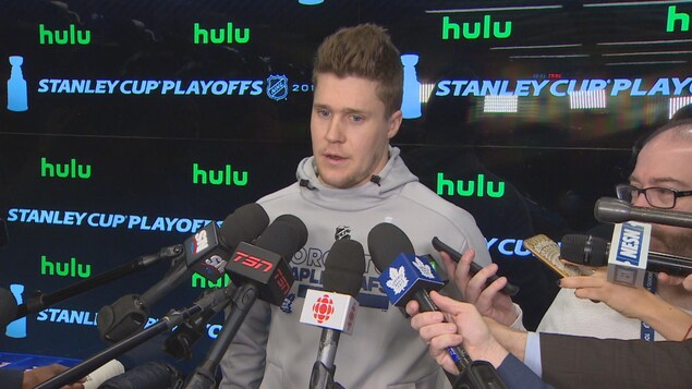 Photo de Jake Gardiner entouré des micros de journalistes dans le vestiaire des Leafs. Photo de Jake Gardiner entouré des micros de journalistes dans le vestiaire des Leafs.