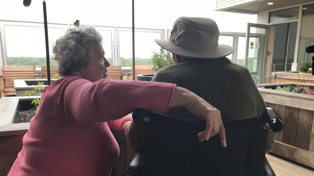 Un couple de personnes âgées, de dos, sur une terrasse de toit. Un couple de personnes âgées, de dos, sur une terrasse de toit.