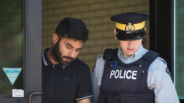 Jaskirat Singh Sidhu est escorté par un policier.