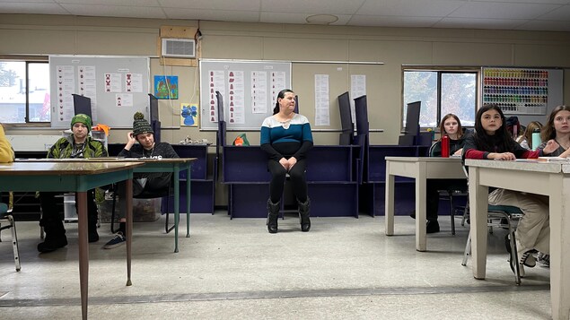 Jasmine Peone est au fond de la classe derrière des élèves qui regardent le tableau.