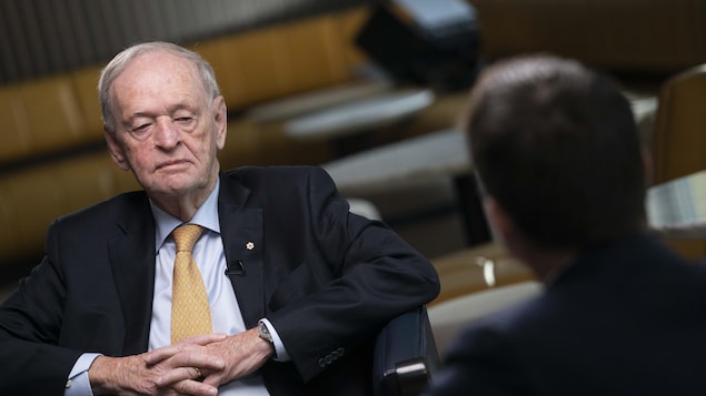 M. Chrétien est assis, de face, et écoute Patrice Roy, que l'on voit de dos.