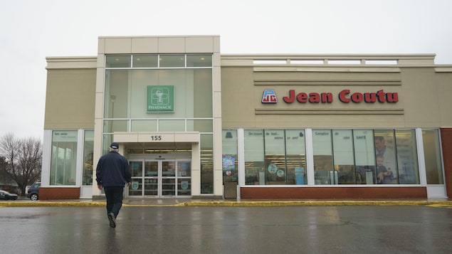 Un homme se dirige vers l'entrée d'une pharmacie Jean Coutu.