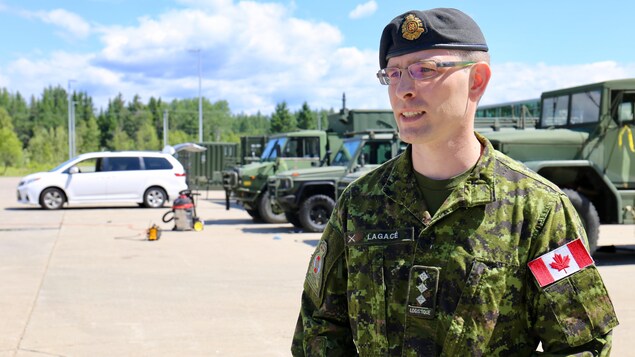 Un militaire est habillé en habit de camouflage vert. Un militaire est habillé en habit de camouflage vert.