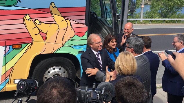 M. Lisée et Mme Hivon serrent des mains devant les caméras.