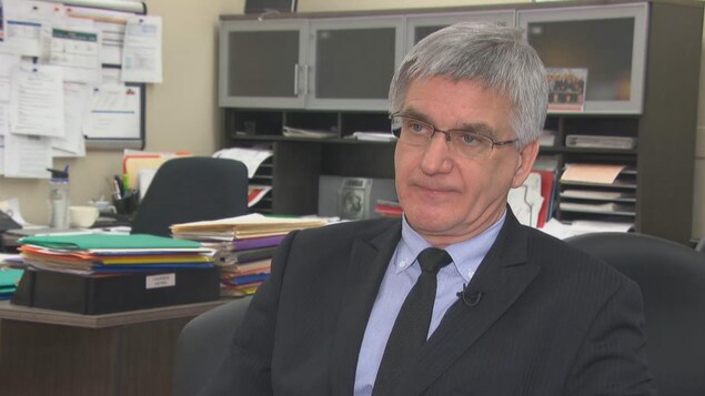 Un homme en complet assis devant un bureau lors d'une entrevue à la caméra de Radio-Canada.