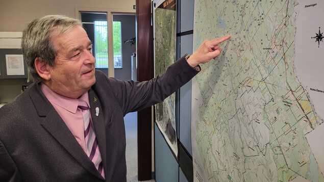 Jean-Yves St-Arnaud qui pointe un endroit sur une carte.