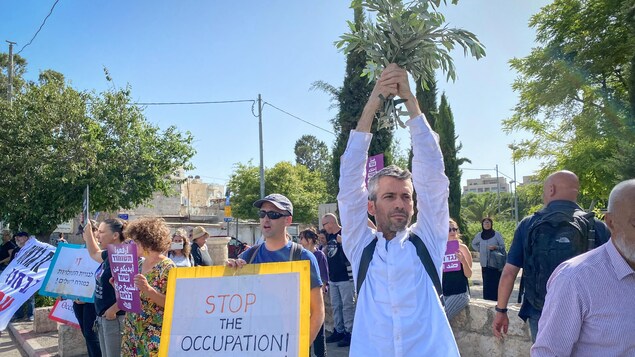 Des Israéliens avec pancarte demandant la fin de l'occupation.
