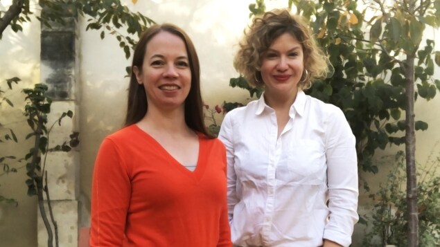 Les deux femmes posent côte à côte et sourient en regardant l'objectif.
