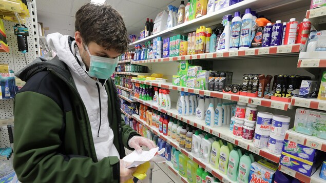 Le jeune homme qui porte un masque regarde une liste.