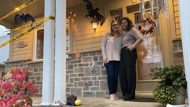 Une jeune femme et sa mère devant leur maison