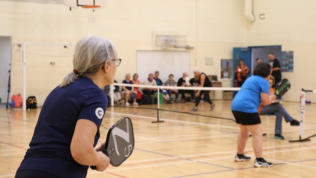 Une dame joue au pickleball.
