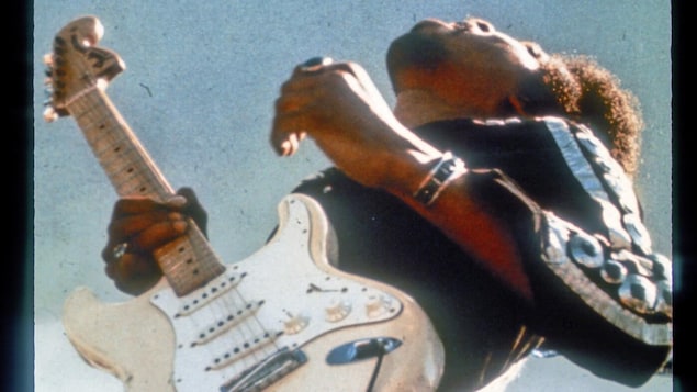 Jimi Hendrix, guitare à la main.