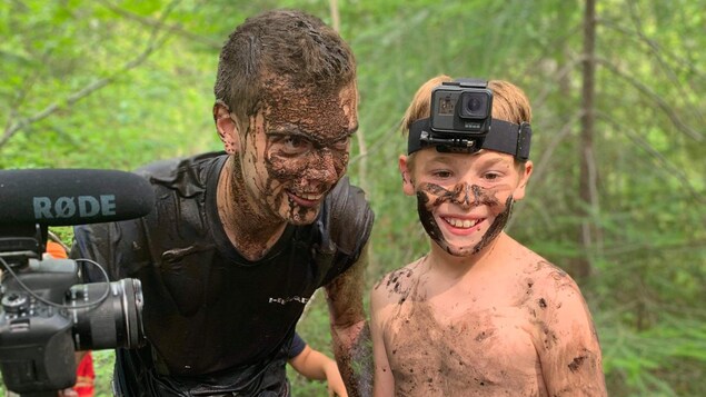 Jimmy Chabot est couvert de boue et tient un appareil photo