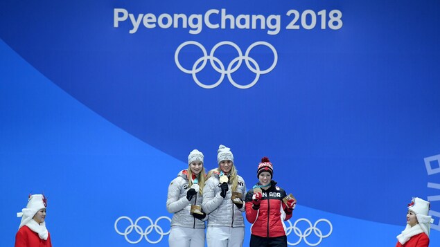 Alex Gough (à droite) avec sa médaille de bronze sur le podium olympique des Jeux d’hiver de 2018 Alex Gough (à droite) avec sa médaille de bronze sur le podium olympique des Jeux d’hiver de 2018