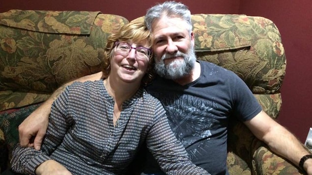 Johanne Labelle avec son mari Robert Labelle, sur un canapé.