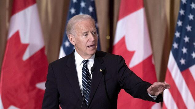 Le vice-président américain Joe Biden devant des drapeaux canadiens et américains