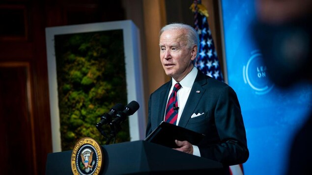 Le président Biden parle derrière une tribune.