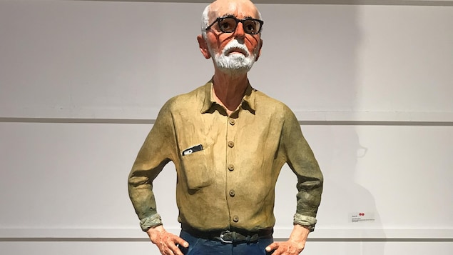 Une scupture représentant l'artiste Joe Fafard, debout, le téléphone dépassant de la poche de sa chemise.