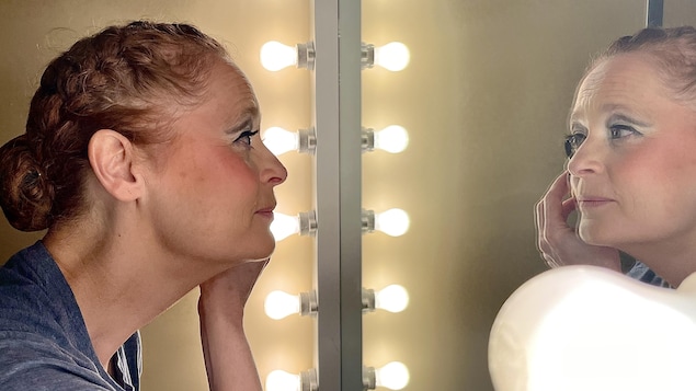 La directrice artistique de Tam ti delam, Johanne Poirier, ajustant son maquillage devant un miroir.