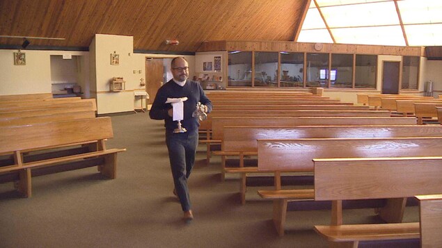 Le père John Molina dans son église. Le père John Molina dans son église.