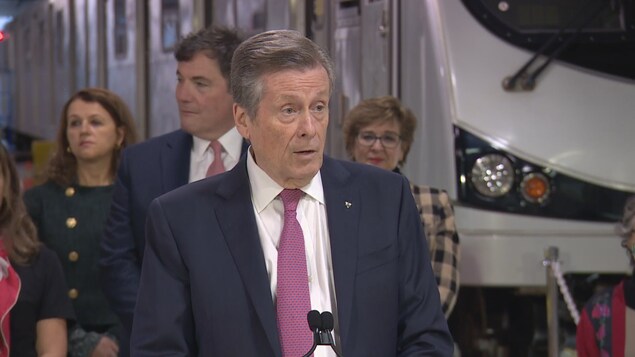 John Tory en point de presse devant une rame de métro.