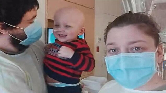 Johnny et Jessica discutent via Messenger. Le bébé est dans les bras de son papa. Ils sont à l'hôpital.